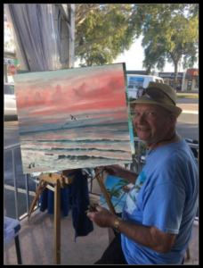 Lloyd Dobson Artist sitting at easel with the finished oil painting titled "Evening After The Storm"