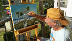 Lloyd Dobson Artist creating a beach themed painting on his lanai
